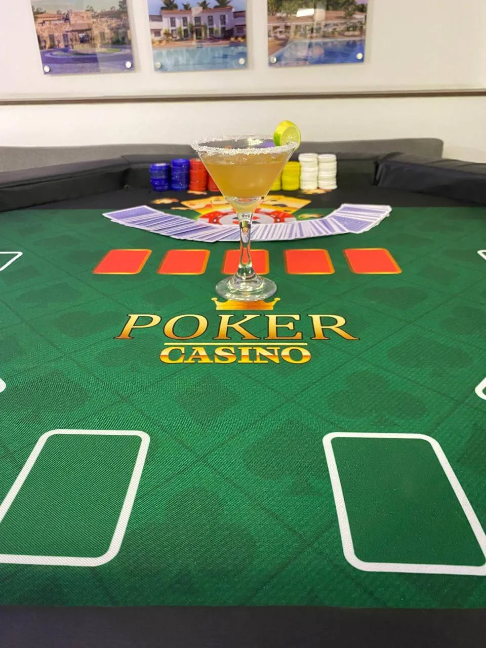 mesa de póker con una copa, cartas y fichas en medio